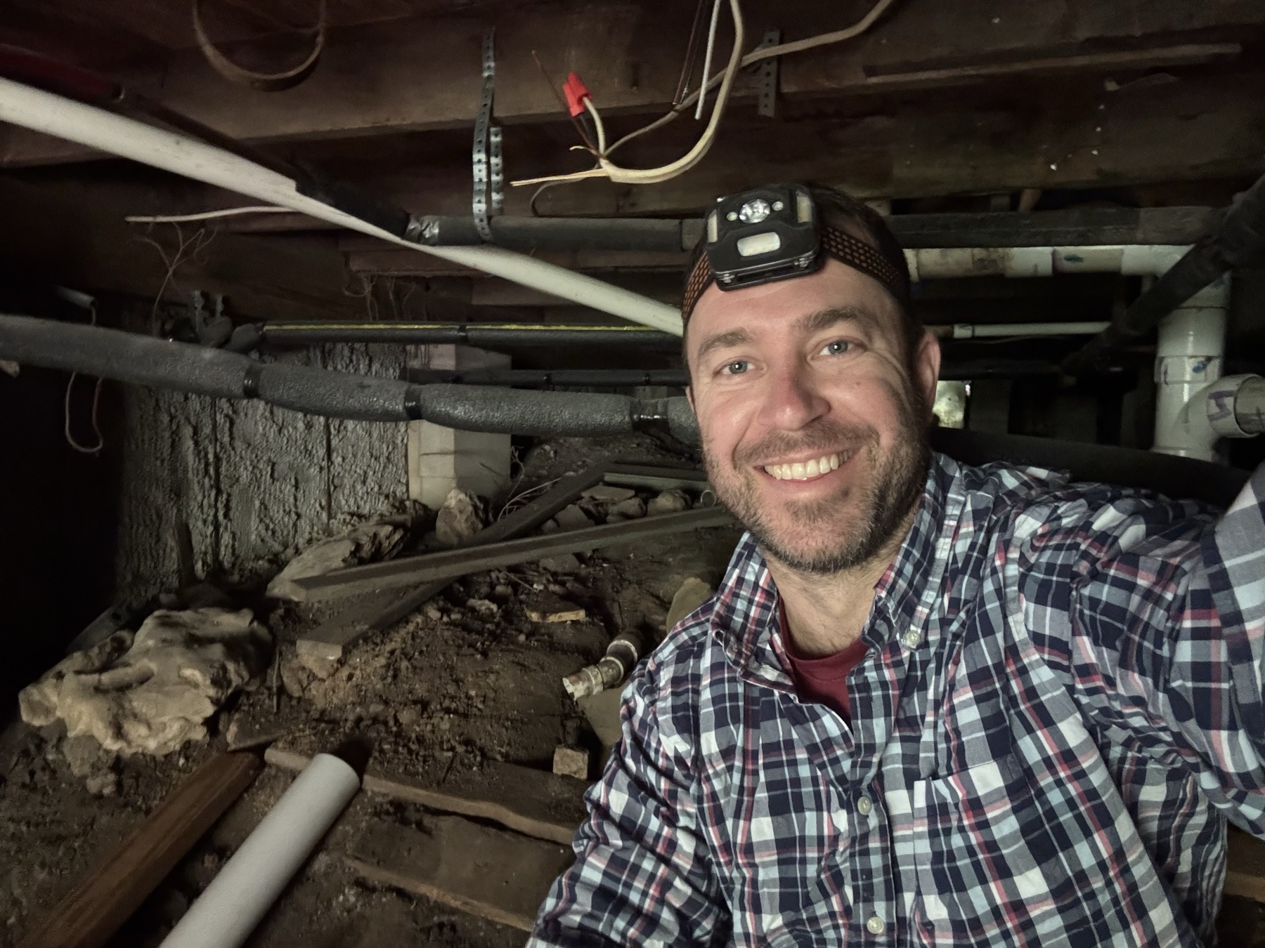 Electrician working under a house
